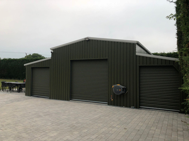 Green barn-style build with roller doors